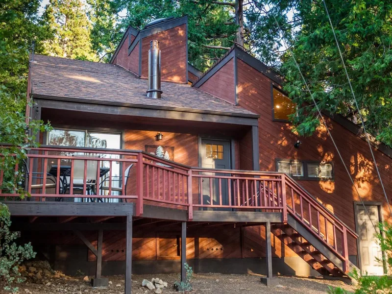 Be Pine, a two-story cabin with a wraparound deck among the pines