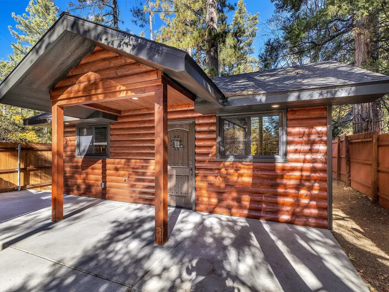 The Lookout, a log cabin with a covered porch behind a wooden fence